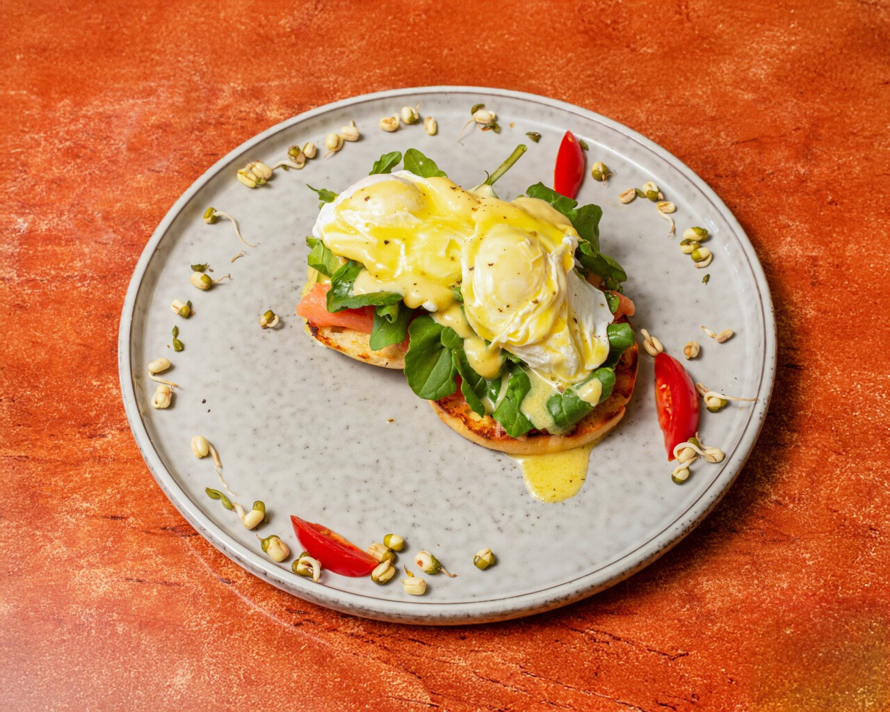 Eggs Benedict with hollandaise sauce and fresh greens