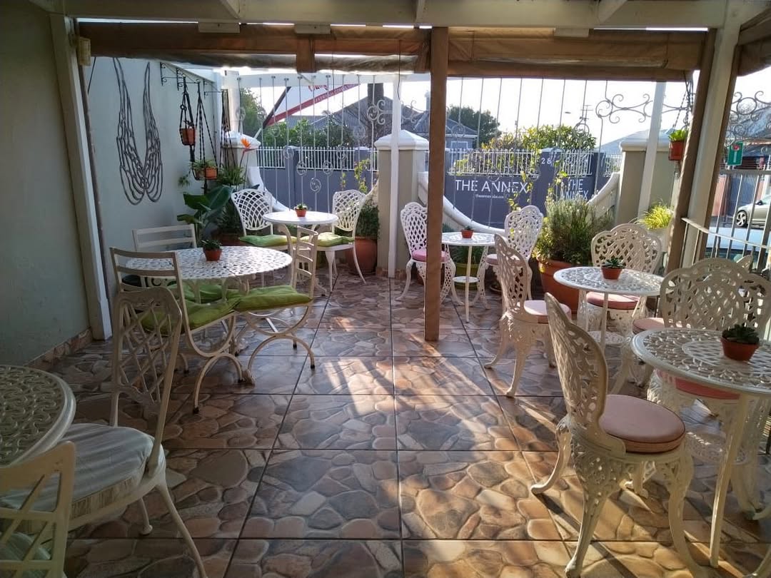Beautiful covered outdoor patio with white wrought iron furniture