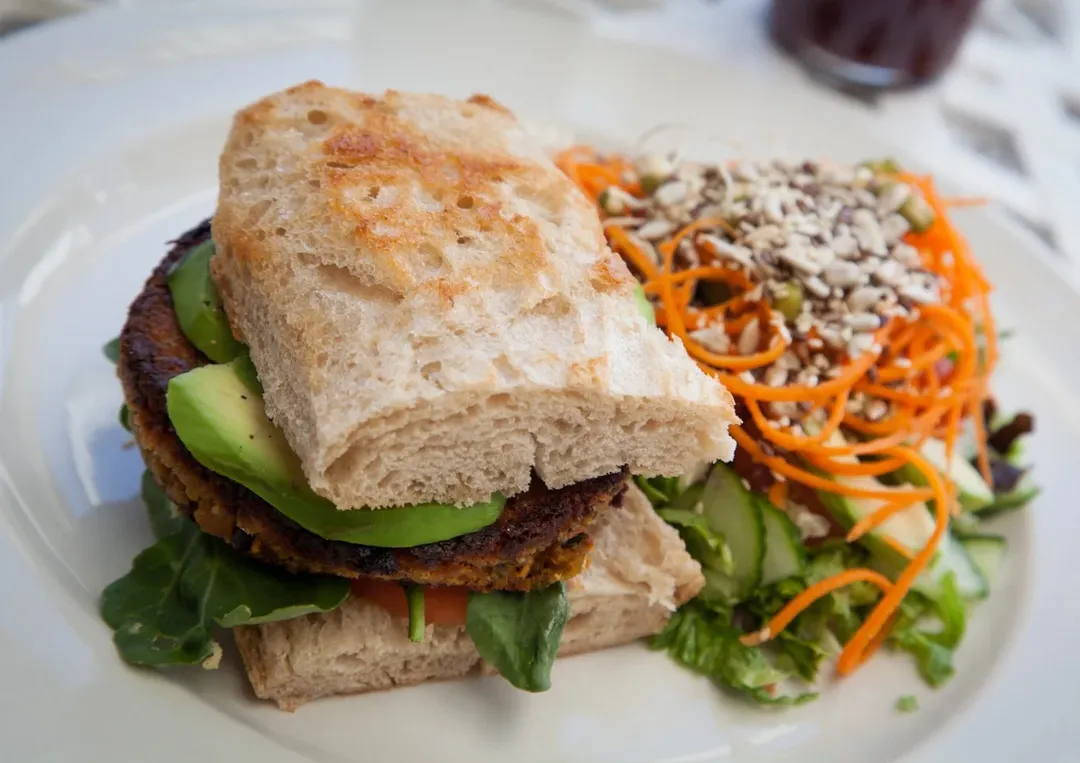 Plant-based burger with avocado and colorful salad